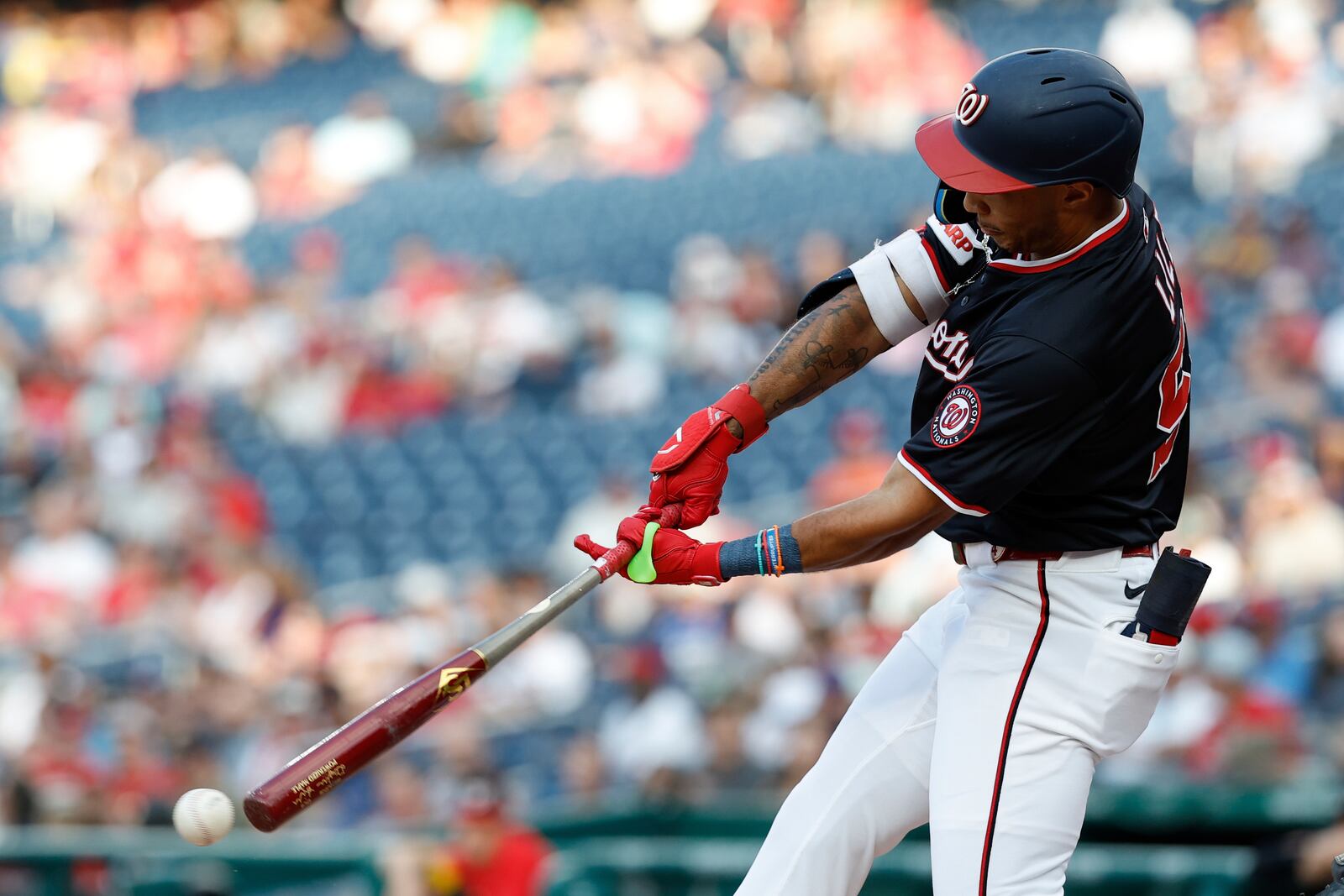 Washington Nationals' Daylen Lile hits a triple off Cincinnati Reds pitcher Brady Singer which scored James Wood, Josh Bell and Nathaniel Lowe during the first inning of a baseball game in Washington, Monday, July 21, 2025. (AP Photo/Terrance Williams)