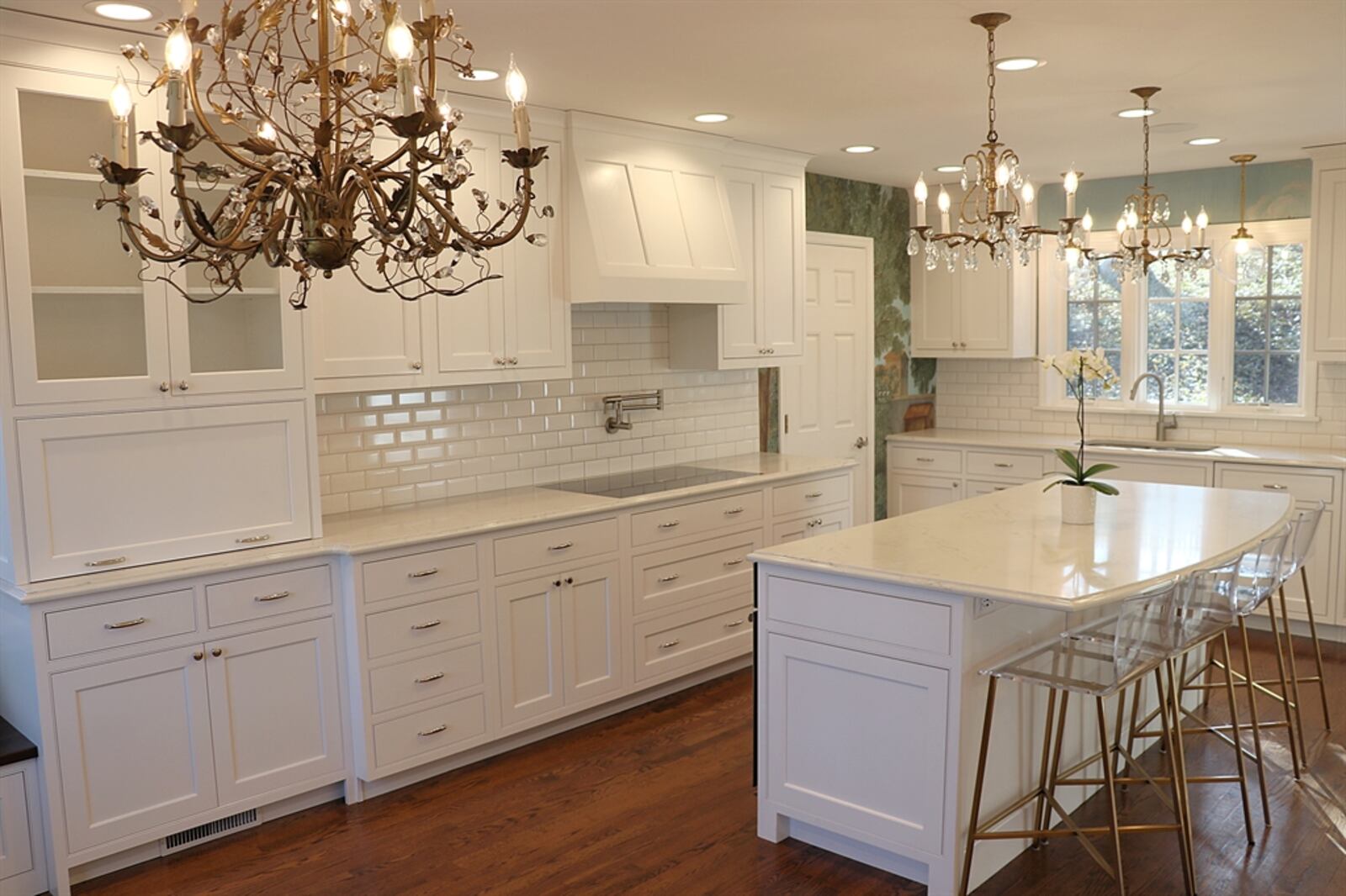 In the kitchen, white subway tile complements the cabinetry and mural wallpaper gives the remaining wall space a splash of color.