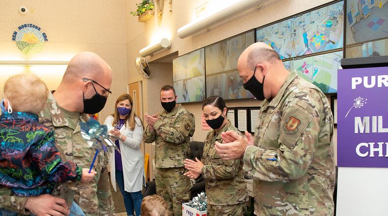 Col. Patrick Miller, 88th Air Base Wing and installation commander, joins 88th Force Support Squadron leadership applauding Alex and Ben Shotts as they leave the New Horizons Child Development Center on April 30 with their father, Staff Sgt. Ethan Shotts of the National Air and Space Intelligence Center. Wright-Patterson Air Force Base’s child development centers closed out Month of the Military Child by having children walk a purple carpet with applause as they left at day’s end. U.S. AIR FORCE PHOTO/R.J. ORIEZ