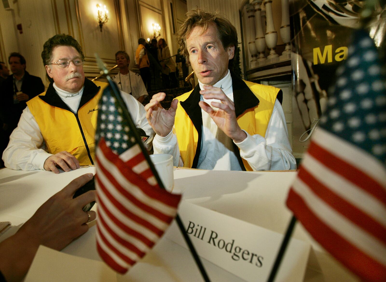 FILE - Four-time Boston Marathon winner, Bill Rodgers, speaks, as Boston Marathon wheelchair winner and pioneer, Bob Hall, listens at left, during a news conference in Boston, April 15, 2005. (AP Photo/Elise Amendola, File)