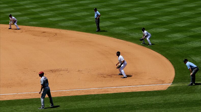 DENVER, CO - JUNE 25:  A defensive shift makes for a busy right side of the diamond including (L-R) shortstop Daniel Descalso #3 of the Colorado Rockies, first base coach Dave McKay #39 of the Arizona Diamondbacks, second base umpire Jeff Nelson, first baseman Wilin Rosario #20 of the Colorado Rockies, second baseman Rafael Ynoa #43 and first base umpire Clint Fagan all prepare for the pitch during the sixth inning at Coors Field on June 25, 2015 in Denver, Colorado. The Rockies defeated the Diamondbacks 6-4. (Photo by Justin Edmonds/Getty Images)