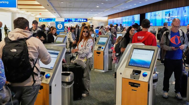 Passengers self check in at the American Airlines counter at Orlando International Airport Tuesday, Nov. 11, 2025, in Orlando, Fla. (AP Photo/John Raoux)