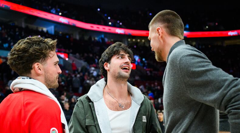 Portland Trail Blazers forward Deni Avdija, center, talks to Atlanta Hawks forwards Corey Kispert, left, and Kristaps Porzingis, right, after an NBA basketball game on Thursday, Jan. 15, 2026, in Portland, Ore. (AP Photo/Molly J. Smith)