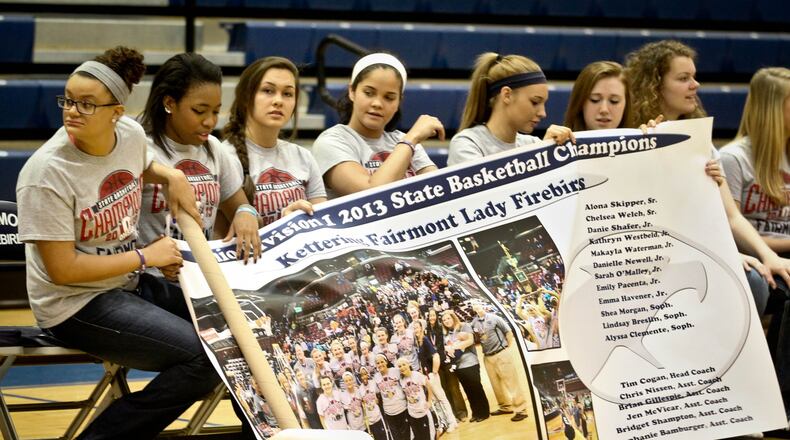 Members of the Fairmont High School girls basketball team unfurl a banner commemorating their Division I state title. The Firebirds were honored at Trent Arena on Tuesday with a ceremony attended by student, staff and local dignitaries. Fairmont completed a 27-1 season by defeating Twinsburg 52-48 in the title games. Twinsburg beat Fairmont in the previous two state title games. By JIM WITMER / STAFF