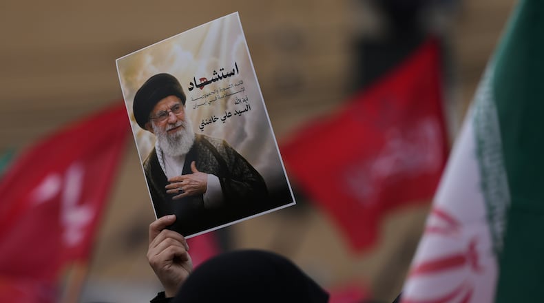 A Hezbollah supporter holds up a portrait of the late Iranian Supreme Leader Ayatollah Ali Khamenei during a gathering in the southern suburbs of Beirut, Lebanon, Sunday, March 1, 2026. The Arabic words on the portrait read:"Martyrdom of the leader of the Islamic revolution in Iran, sayyed Ayatollah Ali Khamenei." (AP Photo/Hassan Ammar)