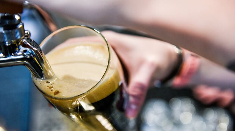 Alex Johnson pours a beer at Fretboard Brewing & Public House on Main Street in downtown Hamilton. The brewery and restaurant offers three levels with bar area on the first floor, a dining room area on the second floor and rooftop dining with a view of the Great Miami River. There are multiple beers on tap, craft cocktails and a section of wine. The food options include pub burger and fries, salads, salmon, steak and more. NICK GRAHAM/STAFF