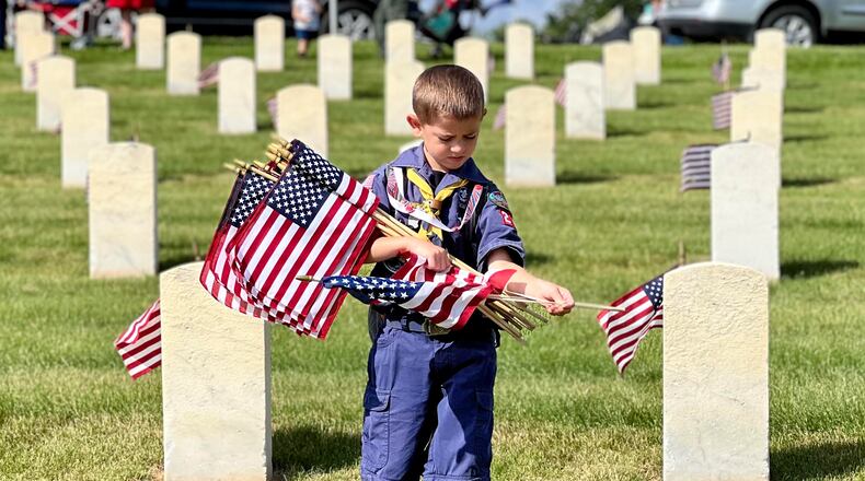 Boy and Girl Scout troops posted American flags at each grave within the Dayton National Cemetery located at the Veterans Medical Center on Saturday. AIMEE HANCOCK/STAFF