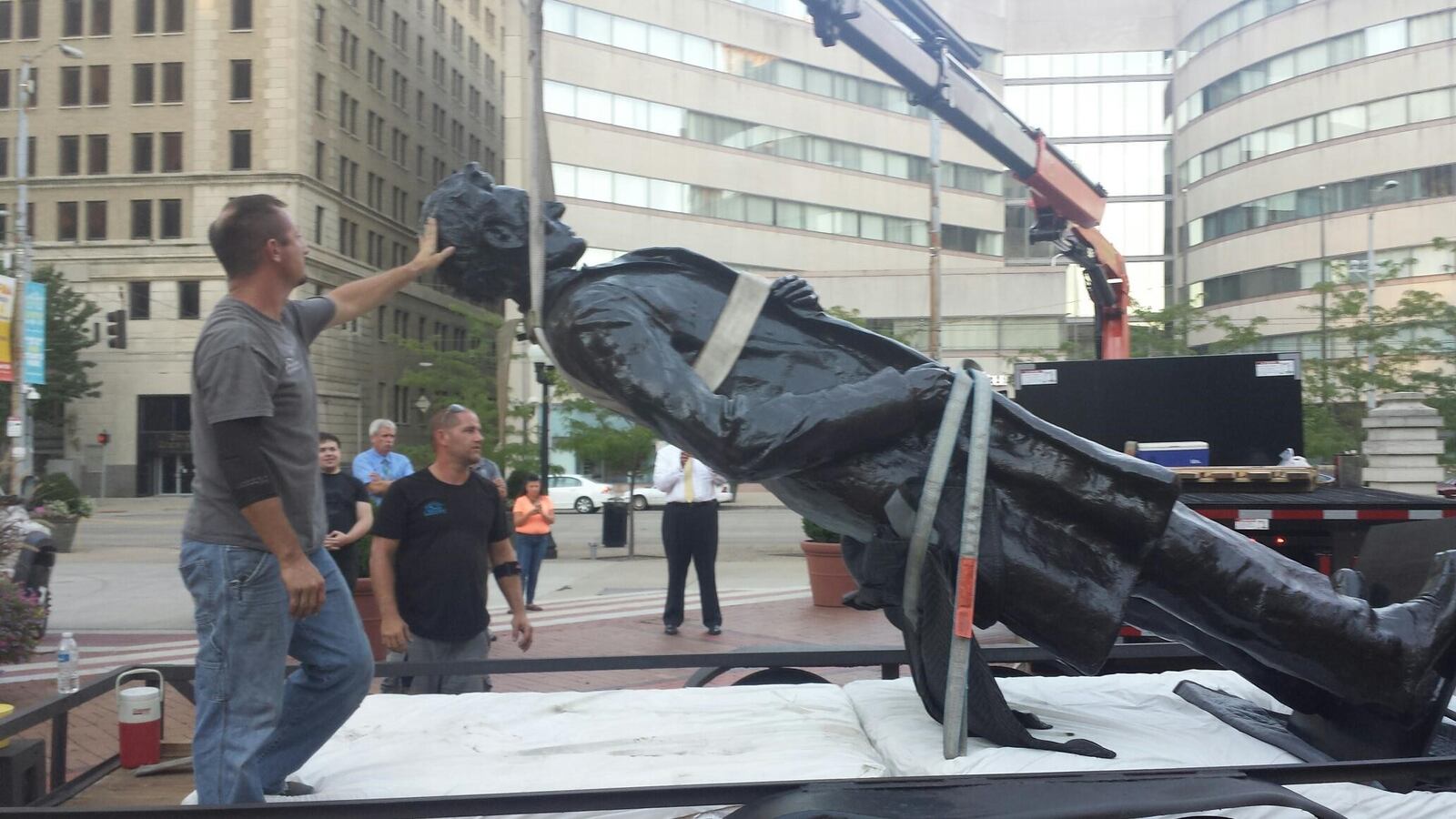 The statue of President Abraham Lincoln is lifted into place on Courthouse Square in Downtown Dayton Monday night. (Regina Payne/Staff)