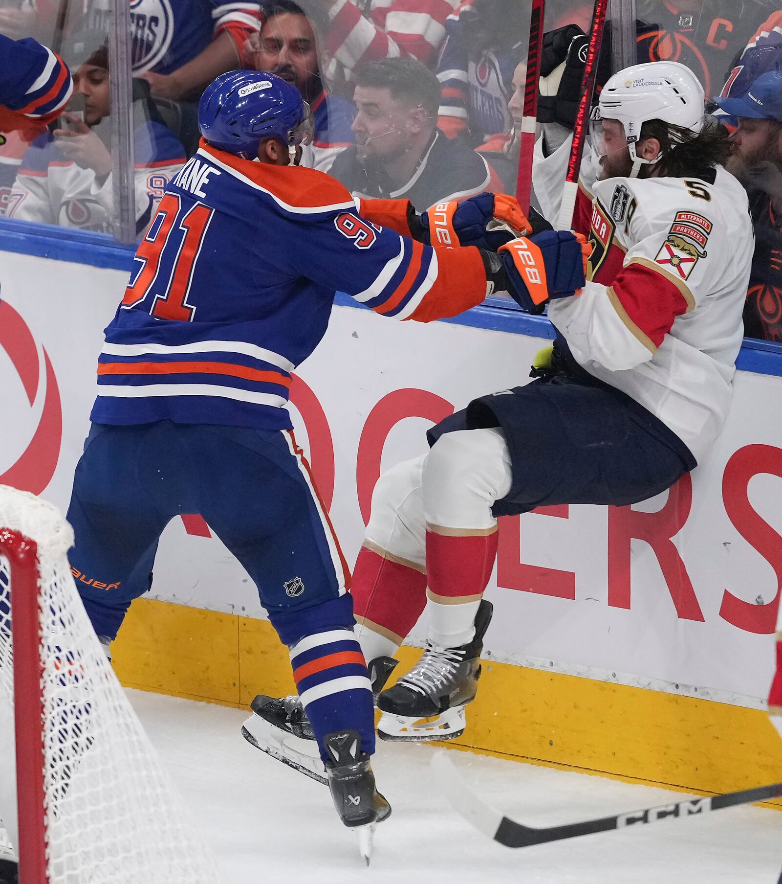 Edmonton Oilers' Evander Kane (91) checks Florida Panthers' Aaron Ekblad (5) during the first period in Game 1 of the NHL Stanley Cup Final, in Edmonton, Alberta, on Wednesday, June 4, 2025. (Darryl Dyck/The Canadian Press via AP)