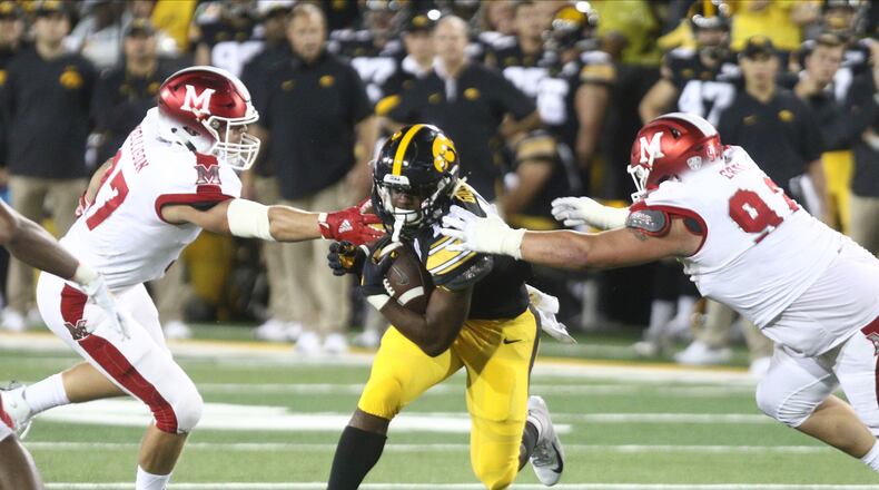 IOWA CITY, IOWA- AUGUST 31: Running back Tyler Goodson #15 of the Iowa Hawkeyes rushes up field during the second half between defensive lineman Austin Ertl #92 and Will Kellison #97 of the Miami Ohio RedHawks on August 31, 2019 at Kinnick Stadium in Iowa City, Iowa. (Photo by Matthew Holst/Getty Images)