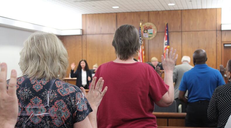 Visitors to Dayton Municipal Court in 2018 raise their right hands to swear they will tell the truth in testimony about eviction cases. CORNELIUS FROLIK / STAFF