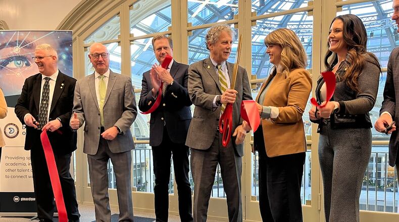 Guests and officials including U.S. Rep. Mike Turner and U.S. Sen. Sherrod Brown cut the ribbon at the Great Lakes Mission Acceleration Center at the downtown Dayton Arcade on Friday Dec. 15, 2023. THOMAS GNAU/STAFF
