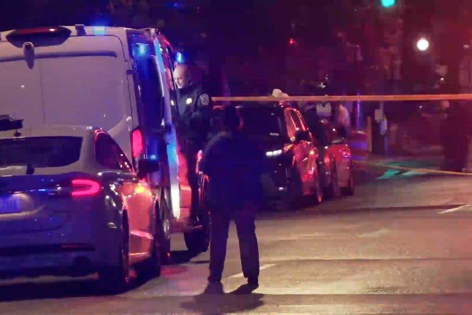 In this image taken from video provided by WJLA, a spectator watches as law enforcement works the scene after two staff members of the Israeli embassy in Washington were shot and killed outside the Capital Jewish Museum on Wednesday, May 21, 2025, in Washington. (WJLA via AP)