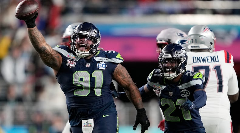 FILE - Seattle Seahawks defensive tackle Byron Murphy II (91) celebrates with cornerback Devon Witherspoon (21) after recovering a fumble by New England Patriots quarterback Drake Maye during the second half of the NFL Super Bowl 60 football game, Feb. 8, 2026, in Santa Clara, Calif. (AP Photo/Doug Benc, File)