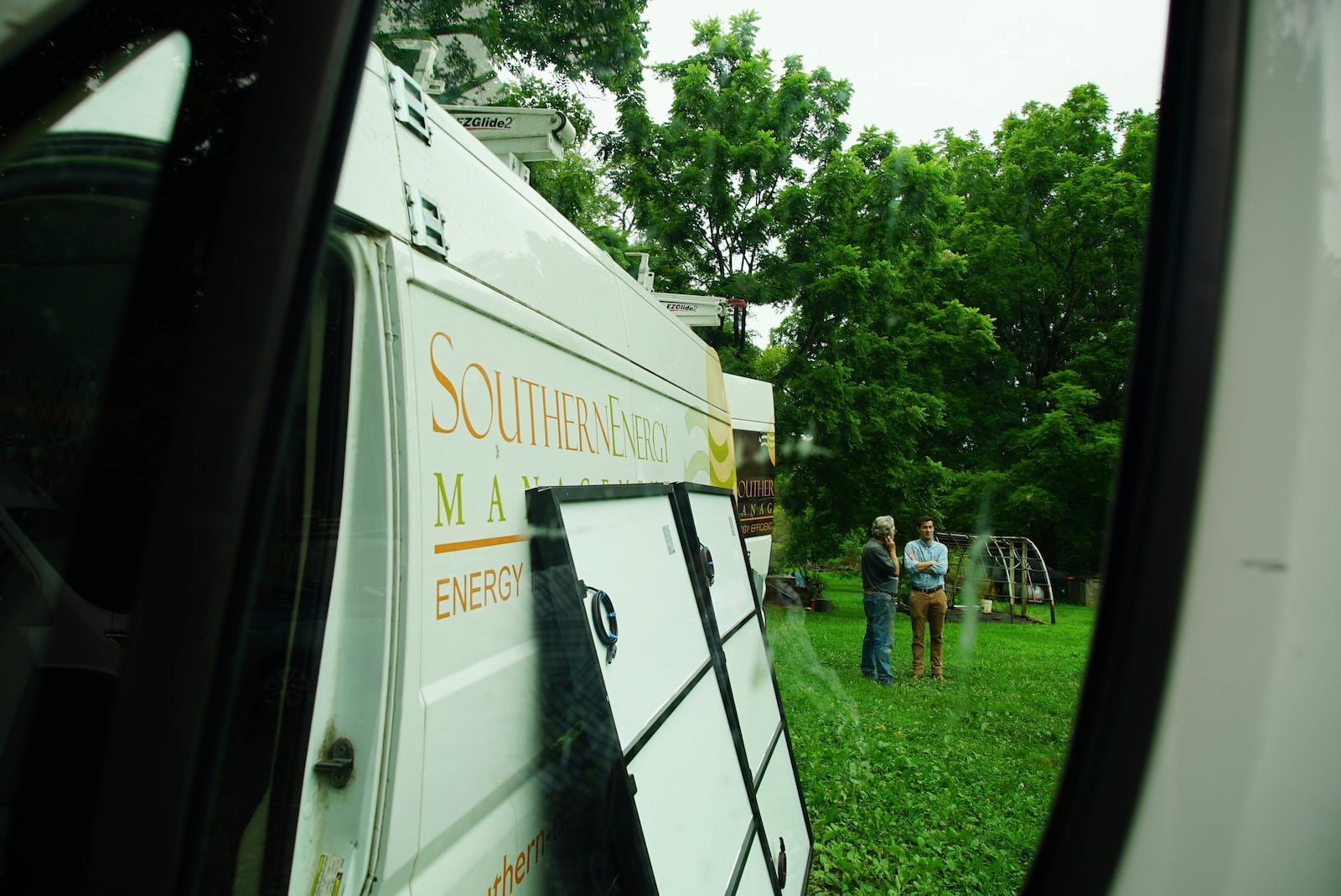 James Asbill, left, speaks with Will Etheridge, CEO of Southern Energy Management, as solar panels are installed on Asbill's home in Chapel Hill, N.C., Wednesday, July 2, 2025. (AP Photo/Allen G. Breed)