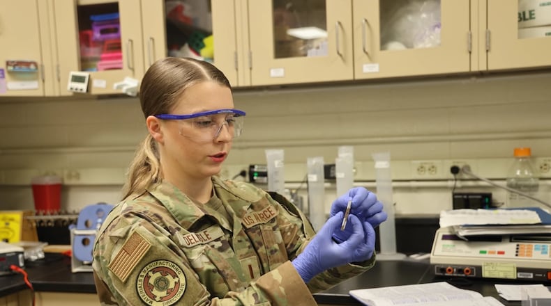 2nd Lt. Evon Delisle, a Biomaterials Research Scientist, prepares muskox guard hair samples to test their break force, or load that the material can sustain before breaking, in the Air Force Research Laboratory, or AFRL, Biomaterials Laboratory of the Materials and Manufacturing Directorate, at Wright-Patterson Air Force Base, in May 2023. (U.S. Air Force photo / Jonathan Taulbee)