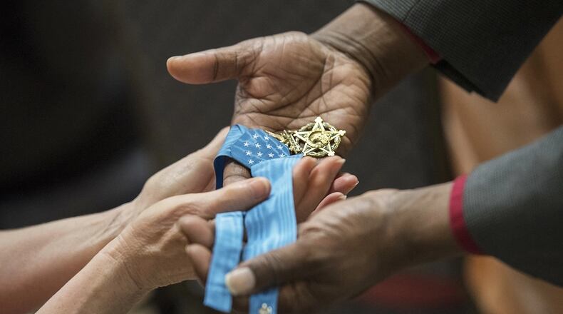 Army civilian employees pass around Retired Master Sgt. Leroy Petry’s Medal of Honor while attending a Mental Health Awareness Observance in 2018 Heritage Hall, Rock Island Arsenal, Illinois.  U.S. Army photo
