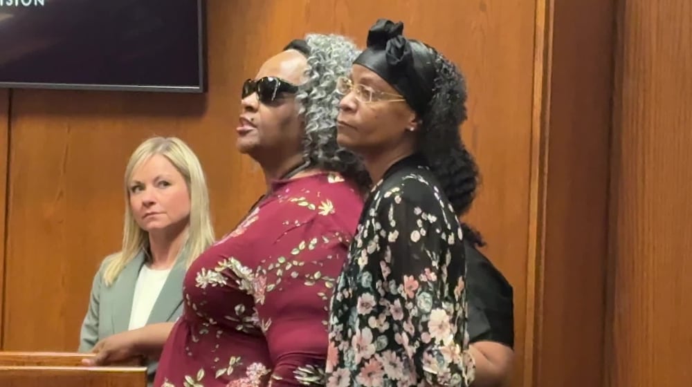 Gloria Courtney, who was blinded in an October 2023 attack while working as a security guard at the Premier Health building downtown, says she forgives her assailant, James Fickling, during his sentencing Friday, March 13, in Montgomery County Common Pleas Court. At right is Courtney's daughter, Oletha Courtney and at left is Jennifer Buschur of the prosecutor's office JEN BALDUF/ STAFF