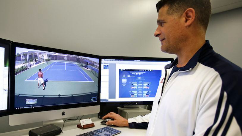 In this Tuesday, Dec. 12, 2017, photo, David Ramos, the U.S. Tennis Association's manager of coaching, education and performance watches video of players practicing at the USTA National Campus in Orlando, Fla. (AP Photo/John Raoux)