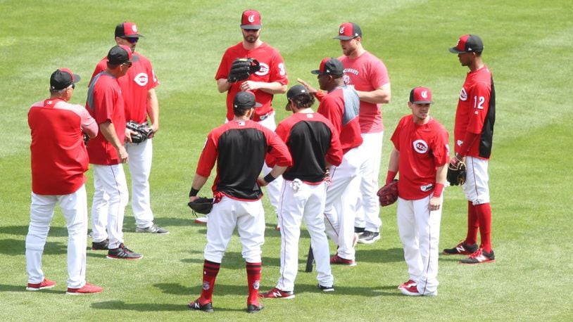 Reds players huddle around Billy Hatcher before batting practice on Monday, May 7, 2018, at Great American Ball Park in Cincinnati. David Jablonski/Staff