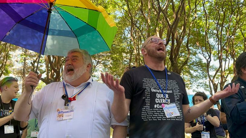 FILE - The Rev. David Meredith, left, and the Rev. Austin Adkinson sing during a gathering of those in the LGBTQ community and their allies outside the Charlotte Convention Center, in Charlotte, N.C., Thursday, May 2, 2024. When the United Methodist Church removed anti-LGBTQ language from its official rules in recent days, it marked the end of a half-century of debates over LGBTQ inclusion in mainline Protestant denominations. The moves sparked joy from progressive delegates, but the UMC faces many of the same challenges as Lutheran, Presbyterian and Episcopal denominations that took similar routes, from schisms to friction with international churches to the long-term aging and shrinking of their memberships. (AP Photo/Peter Smith, File)