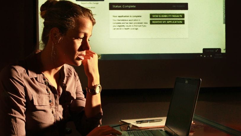 A certified marketplace navigator uses a projector to make it easier for people to see important information on healthcare.gov during open enrollment in 2014. FILE