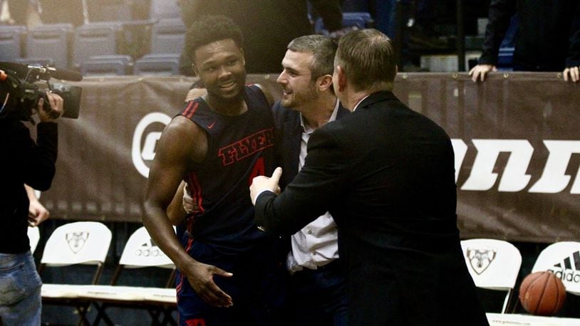 Dayton’s Jordan Davis is congratulated by coaches Brett Comer, center, and Donnie Jones, right, after a victory against St. Bonaventure on Saturday, Jan. 19, 2019, at the Reilly Center in Olean, N.Y. David Jablonski/Staff