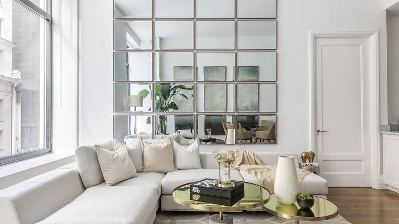 A wall of mirrors helps a small living room feel open and spacious. (Design Recipes)