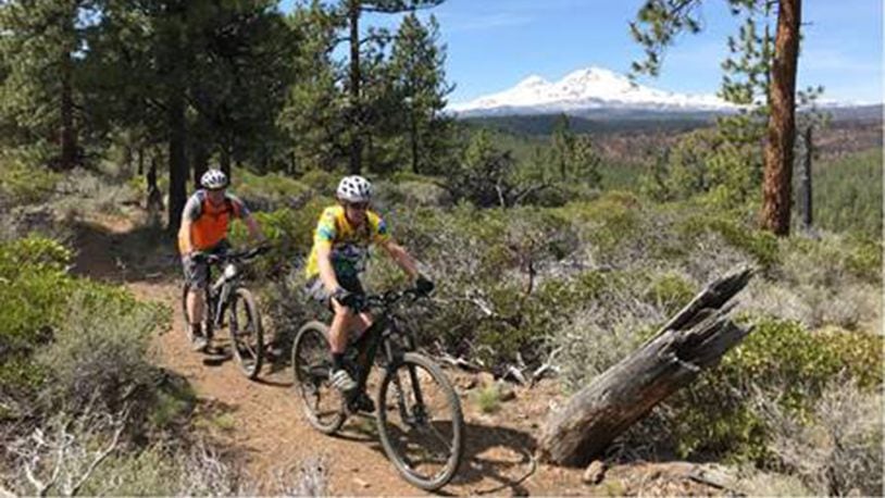 With North and Middle Sister in the background, Bend mountain bikers Alan Kissler, left, and Mark Johnson ride the PRT West trail in the Peterson Ridge Trail system near Sisters. (Mark Morical/Bend Bulletin/TNS)