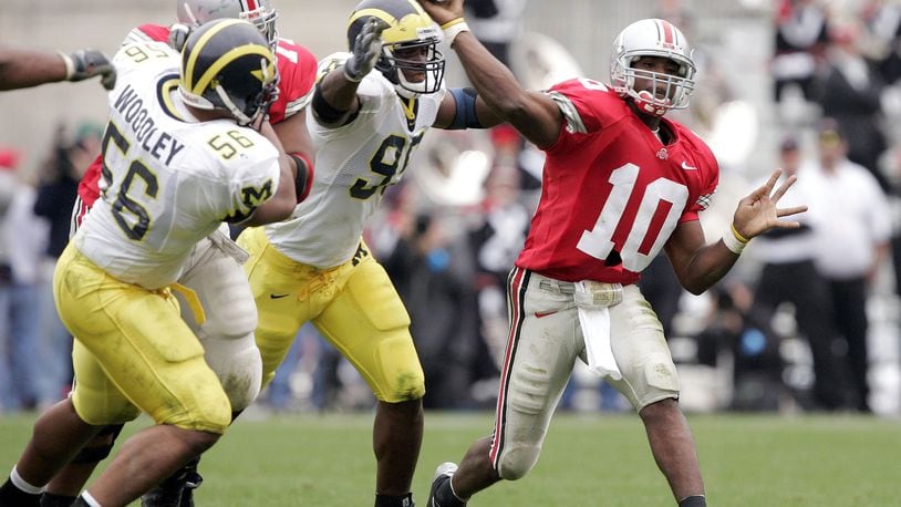 COLUMBUS, OH - NOVEMBER 20:  Quarterback Troy Smith #10 of the Ohio State Buckeyes throws under pressure from defensive end LaMarr Woodley #56 and defensive tackle Marques Walton #95 of the Michigan Wolverines on November 20, 2004 at Ohio Stadium in Columbus, Ohio.  Ohio State upset Michigan 37-21.  (Photo by Brian Bahr/Getty Images)