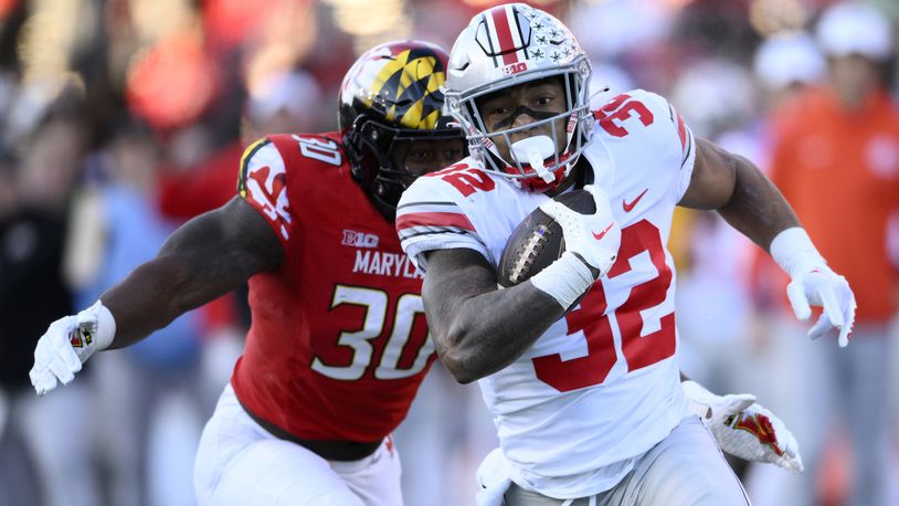 Ohio State running back TreVeyon Henderson (32) runs with the ball past Maryland linebacker Durell Nchami (30) during the first half of an NCAA college football game, Saturday, Nov. 19, 2022, in College Park, Md. (AP Photo/Nick Wass)