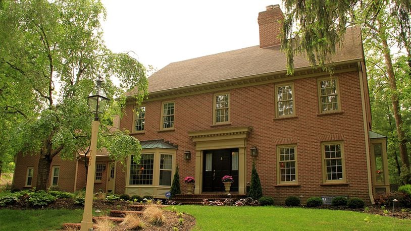 The facade of this brick Georgian Colonial in Washington Twp. incorporates 2 front entrances, a bay window and custom millwork around the main entrance. Brick steps ascend to the side walkway along landscaped flowerbeds and to the brick-floored entrance that leads to the front door. CONTRIBUTED PHOTOS BY KATHY TYLER