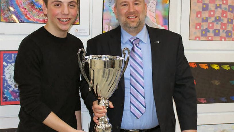 Kettering Middle School Principal Brian Snyder shows off a 2018 attendance trophy with one of his students. The trophy went back to rival Van Buren Middle School last week. CONTRIBUTED