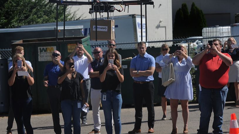 Winsupply employees watch the company's inaugural drone delivery flight arrive at the Centerville Winsupply in Washington Twp. from the Winsupply Distribution Center in Miami Twp. Friday, Aug. 12, 2022. MARSHALL GORBY/STAFF