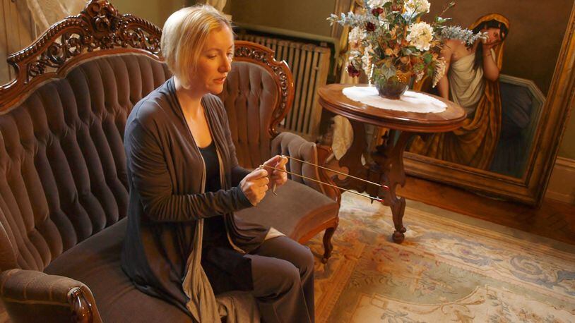 Lynne Bell, an investigator for the Tri-State Ohio Paranormal Society, communicates with Wilhelmina Benninghofen with a pair of divining rods.