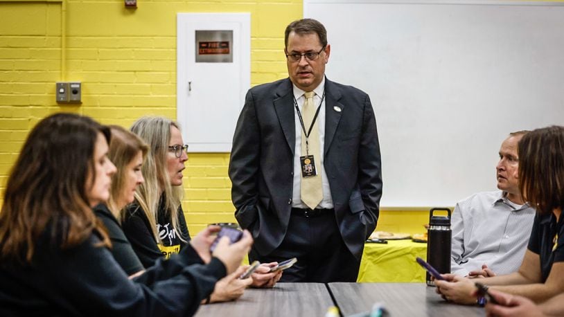 Centerville superintendent Jon Wesney talks to Centerville administrators before heading to the polls to check the outcome. Centerville precincts post results on the doors of polling places. Jim Noelker/Staff