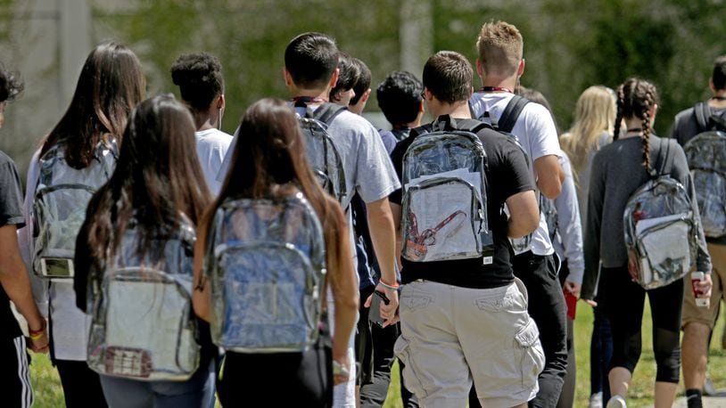 Students wear clear backpacks outside of Marjory Stoneman Douglas High School in Parkland, Fla. on Monday, April 2, 2018. Extra security is one of a number of security measures the school district has enacted as a result of the Feb. 14 shooting at the school that killed 17. (John McCall/Sun Sentinel/TNS)