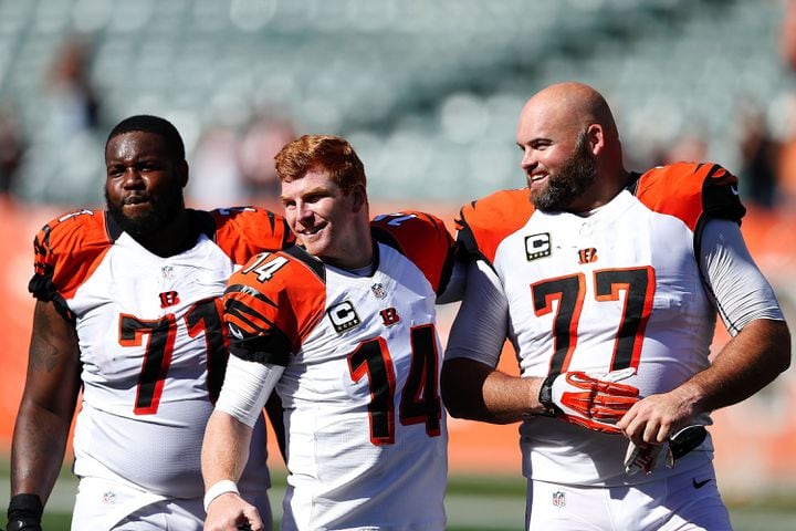 CINCINNATI, OH - SEPTEMBER 14: Andre Smith #71, Andy Dalton #14, and Andrew Whitworth #77, all of the Cincinnati Bengals, walk off of the field after defeating the Atlanta Falcons 24-10 at Paul Brown Stadium on September 14, 2014 in Cincinnati, Ohio. (Photo by Joe Robbins/Getty Images)