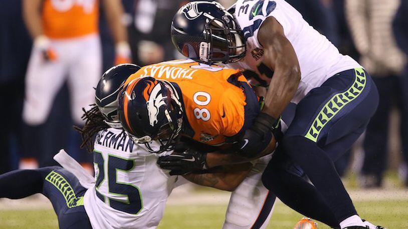 Julius Thomas (80) of the Denver Broncos is hit by Richard Sherman (25) and Kam Chancellor (31) of the Seattle Seahawks during Super Bowl XLVIII at MetLife Stadium in East Rutherford, N.J., on February 2, 2014. (Lionel Hahn/Abaca Press/TNS)