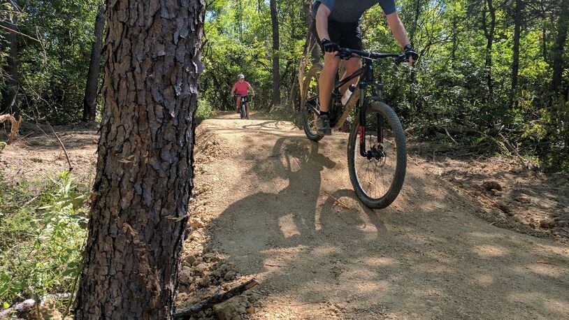 Scott Nash, a teacher in Lebanon, heads downhill on the mountain bike trails at the Premier Health Atrium Medical Center Bike Park in Lebanon. His daughter Kendall is trailing him.