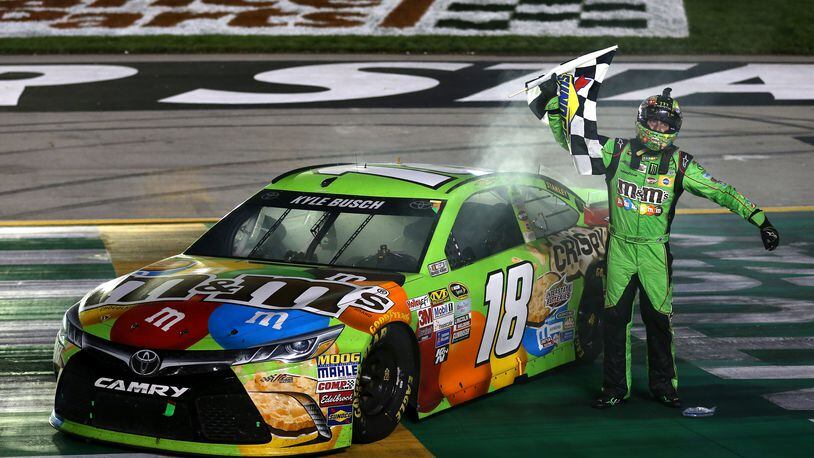 SPARTA, KY - JULY 11: Kyle Busch, driver of the #18 M&M’s Crispy Toyota, celebrates with the checkered flag after winning the NASCAR Sprint Cup Series Quaker State 400 presented by Advance Auto Parts at Kentucky Speedway on July 11, 2015 in Sparta, Kentucky. (Photo by Todd Warshaw/Getty Images)