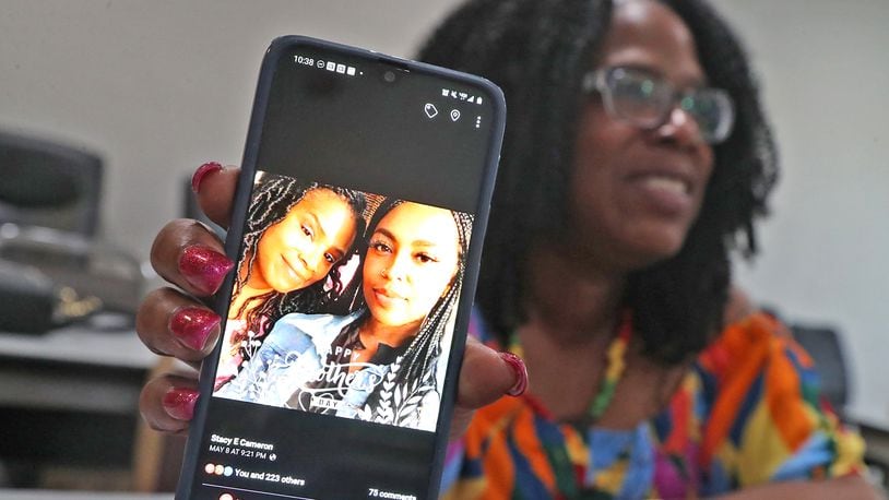 Stacy Cameron hold up her cellphone, showing a photo of her and her daughter Shauna Cameron, Wednesday, May 18, 2022. A Dayton man identified as a "strong" person of interest by police, Jamar Hayes, 26, was charged with murder on May 26 after Shauna was shot and killed May 8 while riding in a car along U.S. 35 in Riverside. BILL LACKEY/STAFF