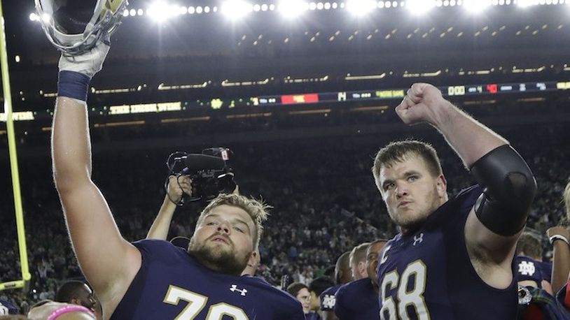 Notre Dame offensive linemen Hunter Bivin (70) and Mike McGlinchey (68) celebrate the team's 49-14 win over Southern California in an NCAA college football game, Saturday, Oct. 21, 2017, in South Bend, Ind. (AP Photo/Carlos Osorio)