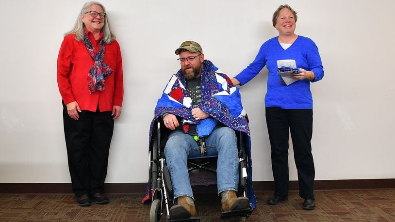 John Clarke is presented a Quilt of Valor from the Miami Valley Quilters Guild during an Operation Veteran and Caregiver Support program earlier this year. Contributed photo