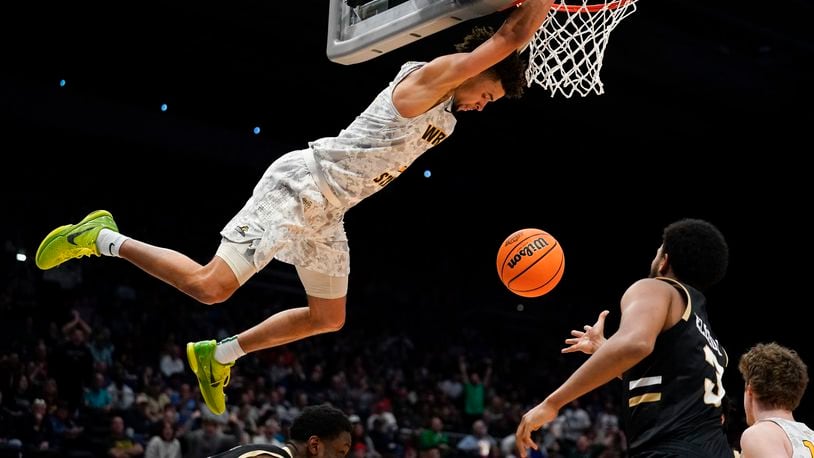 Wright State guard Tanner Holden (2) hangs from the rim after a dunk during the second half of a First Four game in the NCAA men's college basketball tournament against Bryant, Wednesday, March 16, 2022, in Dayton, Ohio. (AP Photo/Jeff Dean)
