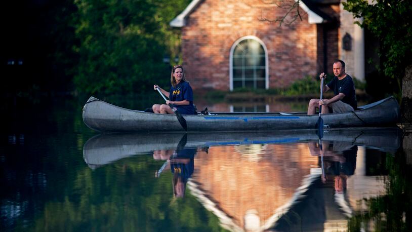 Danny and Alys Messenger canoe away from their flooded home after reviewing the damage in Prairieville, La., Tuesday, Aug. 16, 2016. As waters begin to recede in parts of Louisiana, some residents struggled to return to flood-damaged homes on foot, in cars and by boat. (AP Photo/Max Becherer)