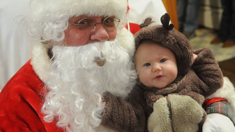 Arabella Slusser, 4 months old, sits with Santa at the New Carlisle fire house after the Christmas parade in December 2016. Miami View Elementary will be providing the chance to take a photo with Santa this Saturday. Staff photo/Marshall Gorby