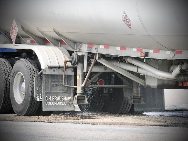 Gasoline tanker truck leaking gas out of large tank