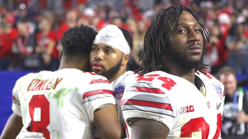 Ohio State's Malik Hooker, right, leaves the field after a loss to Clemson in the Fiesta Bowl on Dec. 31, 2016, as Gareon Conley, left, and Marshon Lattimore hug in the background.