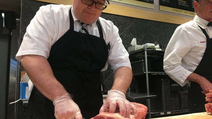Joe Neuhauser, general manager of the meat department at Dorothy Lane Market in Oakwood, cuts a slab of meat before Memorial Day weekend. KARA DRISCOLL/STAFF